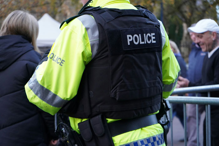 Police officer wearing uniform and safety vest at public event