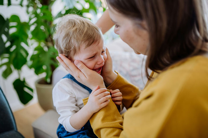 Mom comforting a crying autistic child at home