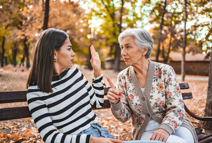 Older woman arguing with younger woman on park bench