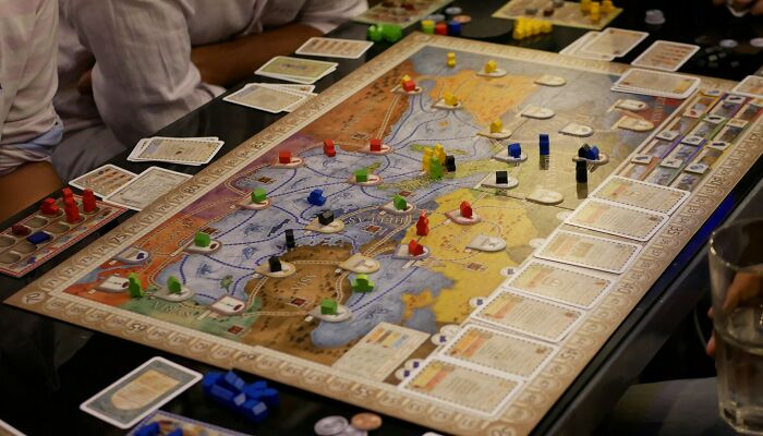 People playing a board game with pawns and cards, illustrating strange jobs as a game tester.