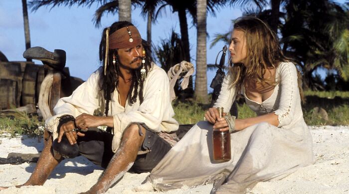 Keira Knightley and Johnny Depp as their characters in Pirates of the Caribbean on a beach. Keira Knightley and Johnny Depp as their characters in Pirates of the Caribbean on a beach.