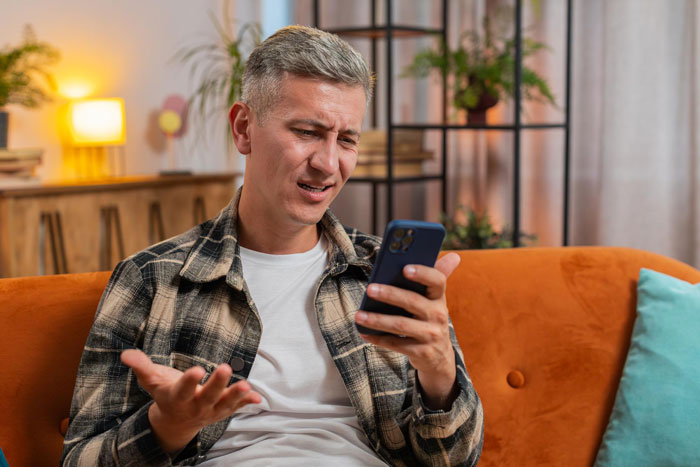 A guy looks confused while looking at his phone, realizing his daughter feels replaced by stepkids and wants a response. A guy looks confused while looking at his phone, realizing his daughter feels replaced by stepkids and wants a response.