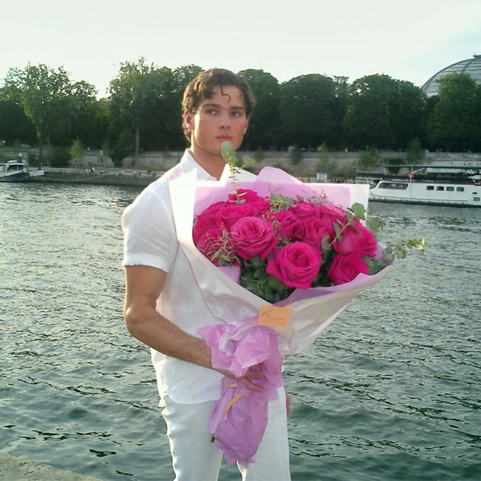 Looksmaxxer Clavicular, a young man, in a white outfit holding a large bouquet of pink roses by the Seine river in Paris. Looksmaxxer Clavicular, a young man, in a white outfit holding a large bouquet of pink roses by the Seine river in Paris.
