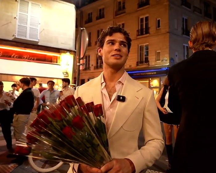 Looksmaxxer Clavicular, a young man, in a white suit holding a large bouquet of red roses in Paris. Looksmaxxer Clavicular, a young man, in a white suit holding a large bouquet of red roses in Paris.