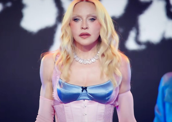 Madonna's performance in Times Square, wearing a pink corset and blue bra, sparks hilarious reactions.