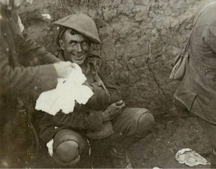 Creepy vintage photo of soldier with eerie grin in trench