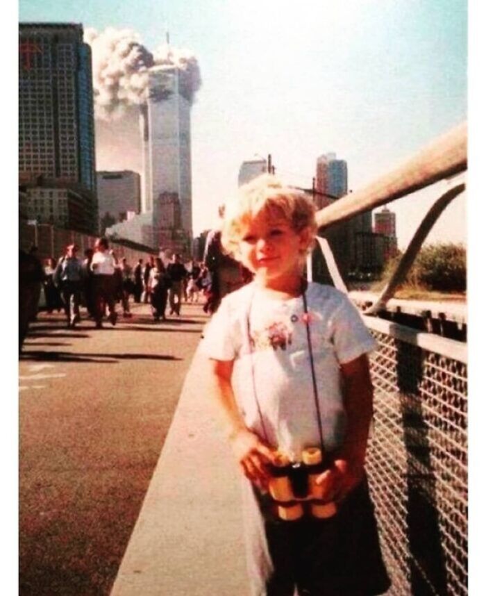 Creepy historical photo of child holding binoculars with Twin Towers explosion in background