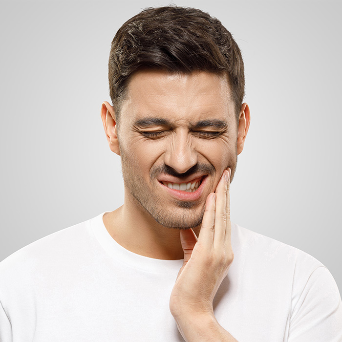 Man in pain holding jaw indicative of jaw transformation