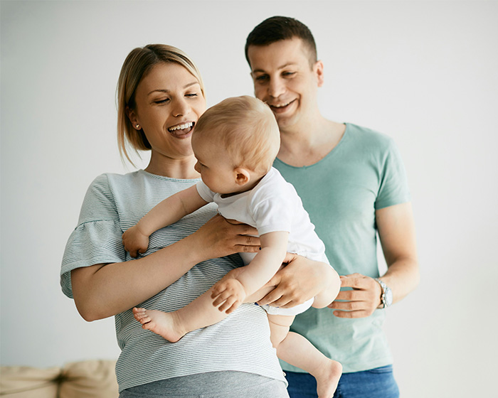 Happy parents holding and playing with their baby at home Happy parents holding and playing with their baby at home