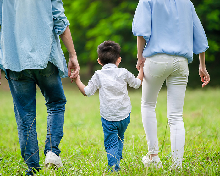 A family walking through a field, where fake photos were used to pretend they had a family. A family walking through a field, where fake photos were used to pretend they had a family.