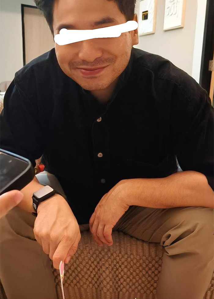 A man smiles, traumatized by the discovery that fake photos were used to pretend he had a family. A man smiles, traumatized by the discovery that fake photos were used to pretend he had a family.