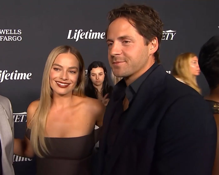 Margot Robbie with her husband, who was in the Harry Potter movie, at an event, smiling for the camera. Margot Robbie with her husband, who was in the Harry Potter movie, at an event, smiling for the camera.
