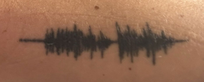 Soundwave tattoo on skin, symbolizing a unique and meaningful tattoo with personal significance.