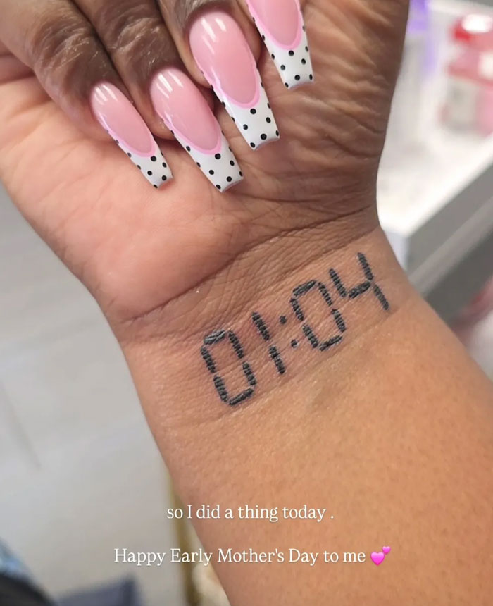 Wrist tattoos showing a digital time stamp (01:04) and elegant french tip nails with polka dots, symbolizing meaning.