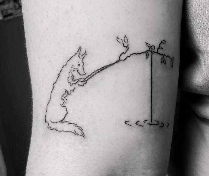 Outline tattoo of a fox playing with a branch on a bicep, a simple yet meaningful tattoo.