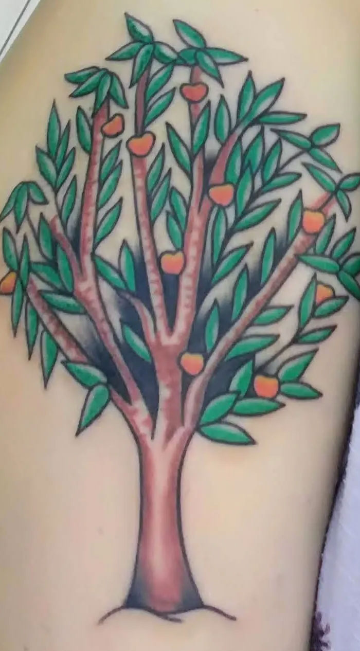 A vibrant tree tattoo with green leaves and orange fruit, representing beautiful and meaningful tattoos.
