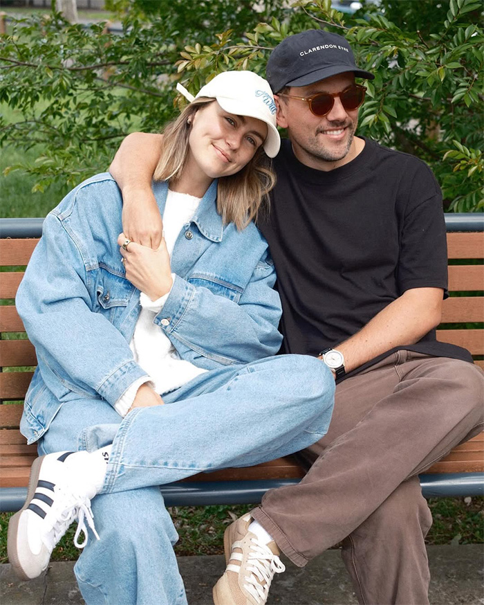 Media personality and a man sitting on a bench, a couple discussing bedroom confession.