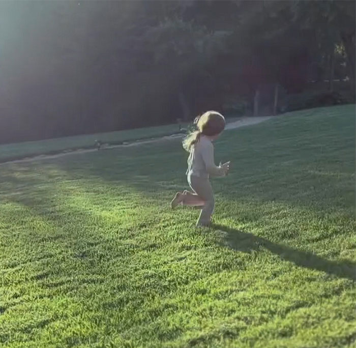 Child running barefoot on grass in sunlight Meghan Markle photo dump