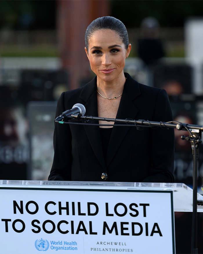 Meghan Markle speaking at podium about social media impact on kids with WHO and Archewell