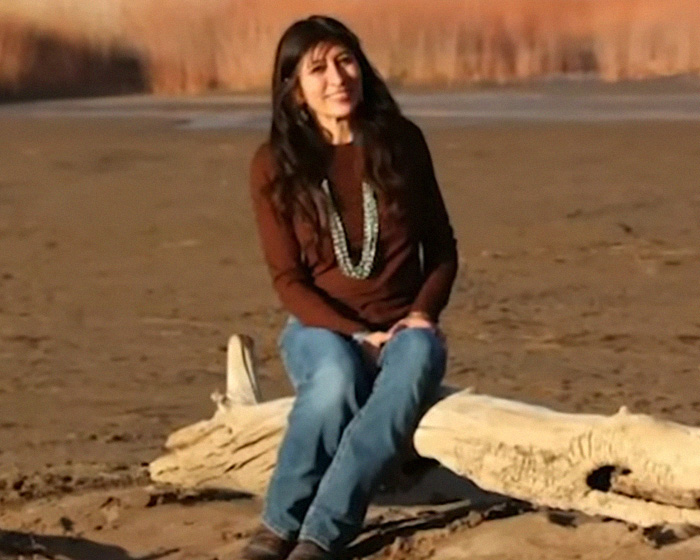 Missing scientist woman sitting on driftwood by a sandy shore Missing scientist woman sitting on driftwood by a sandy shore