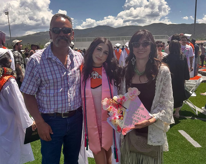 Graduation photo of young woman with her parents outdoors Graduation photo of young woman with her parents outdoors