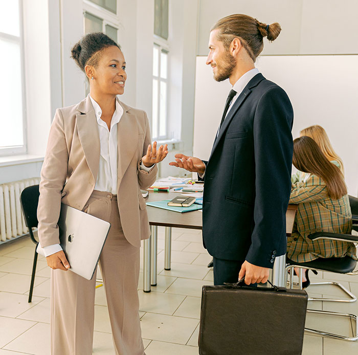Woman and man in business attire discussing in office