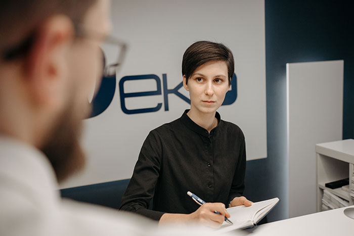 Woman intently listening and taking notes at office desk