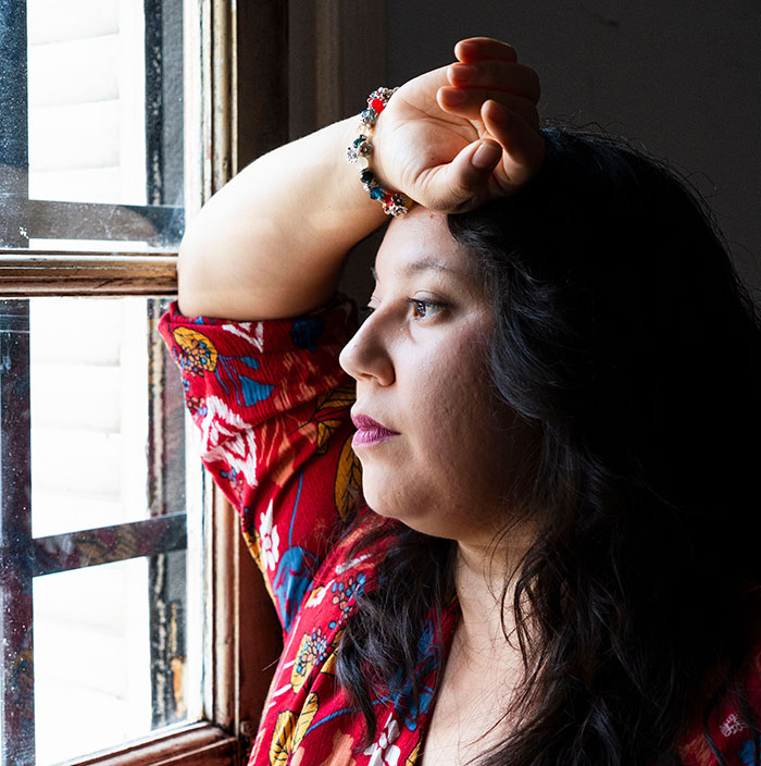 Pensive woman looking out window reflecting free therapists moment