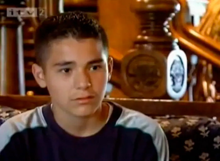 Young man in casual shirt sitting indoors in an interview setting