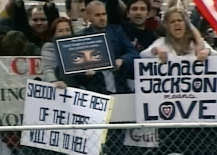 Crowd holding supportive and critical signs about Michael Jackson outside a courthouse