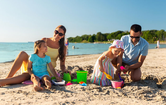 Happy family with kids playing on the beach on Mother's Day.