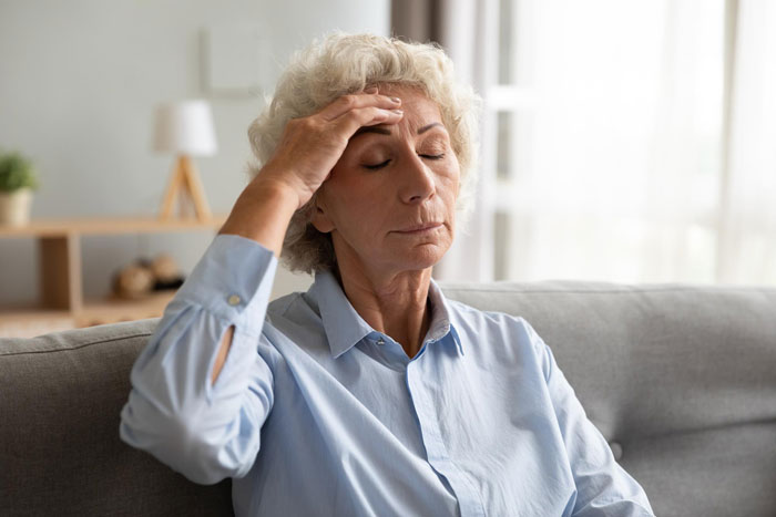 A grandmother, looking stressed, holding her head, reflecting the struggles with an attention-seeker mom on Mother's Day. A grandmother, looking stressed, holding her head, reflecting the struggles with an attention-seeker mom on Mother's Day.