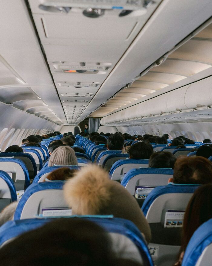Passengers seated inside airplane cabin during flight