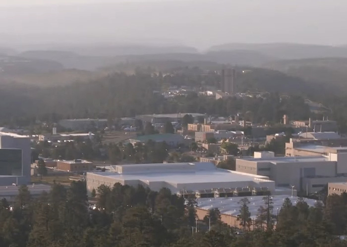 Aerial view of Los Alamos laboratory complex surrounded by forest Aerial view of Los Alamos laboratory complex surrounded by forest