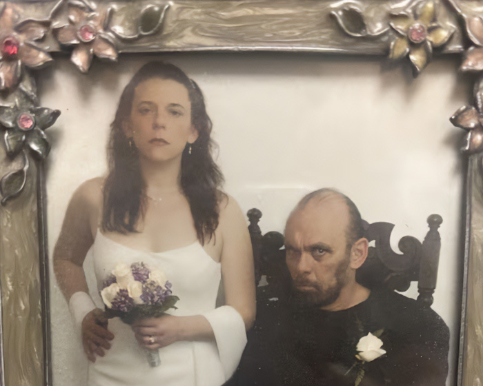 Wedding portrait of a woman in a white dress with a bouquet and a man in a black shirt, linked to the house of horrors story.