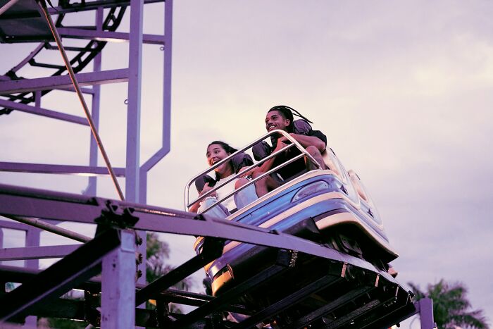 People enjoying roller coaster ride showing human body reactions