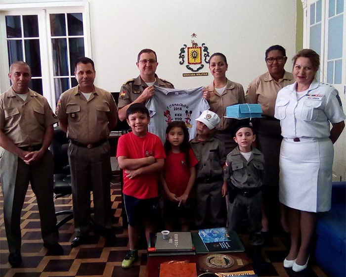 A group of adults and children in uniform, relevant to a mom's actions after her son's changed behavior.