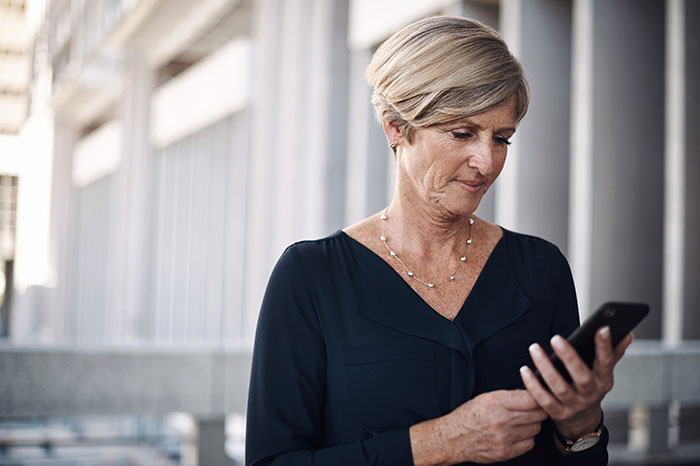 A thoughtful bride's mom looks at her phone, potentially choosing church over the wedding and family photos.