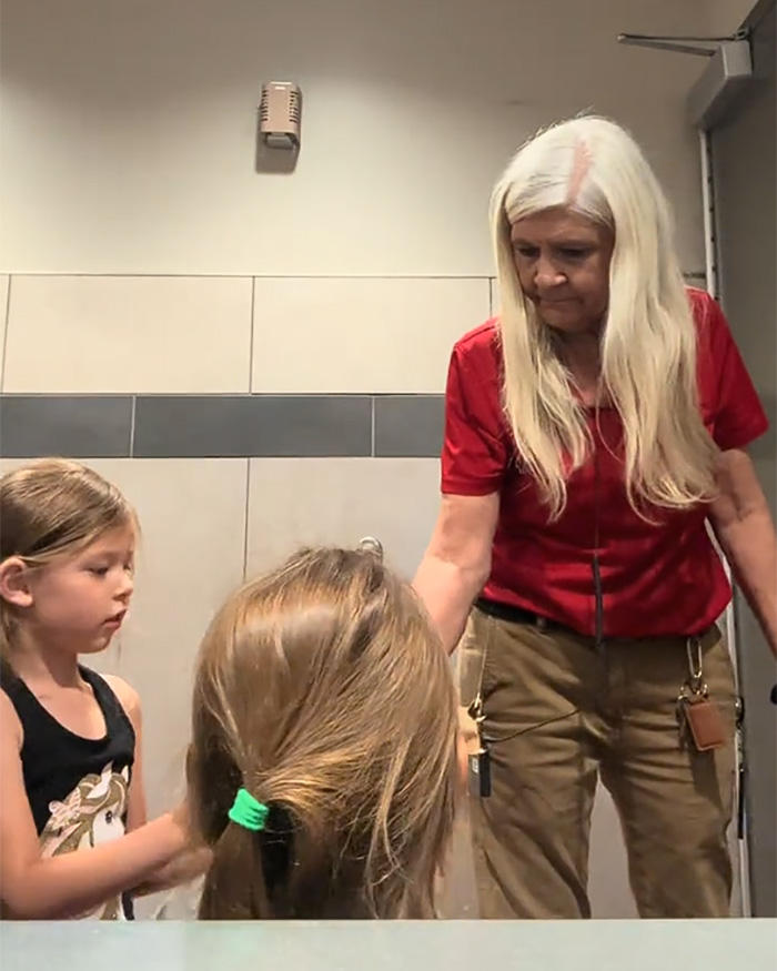 A Mom of girls is seen in a restroom, trying to help her girls with their hair, in the viral restroom video. A Mom of girls is seen in a restroom, trying to help her girls with their hair, in the viral restroom video.