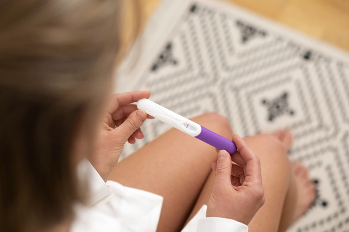 A religious mom holding a pregnancy test, likely found during snooping in her teen's room.