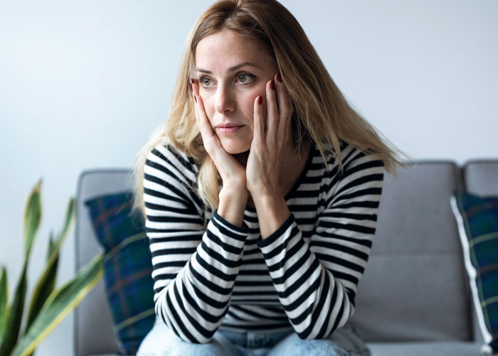 Thoughtful woman in striped shirt reflecting on life changes