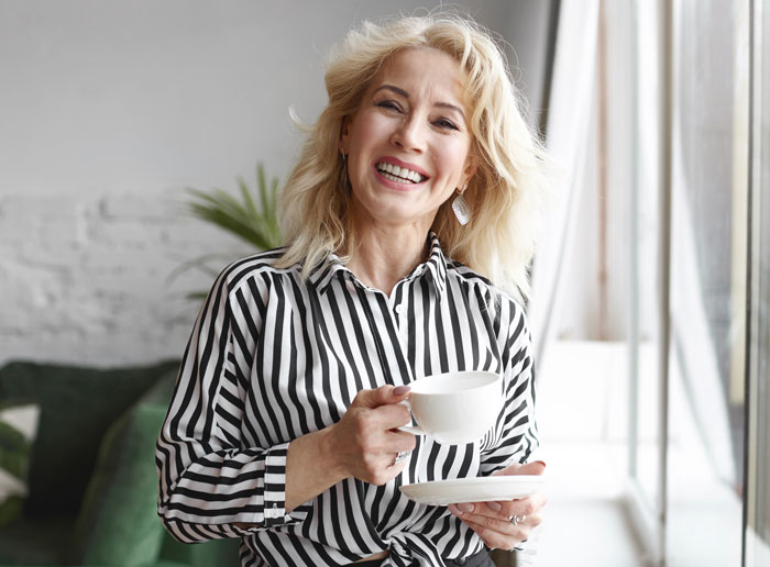 Smiling woman enjoying a cup of coffee symbolizing thriving life after divorce