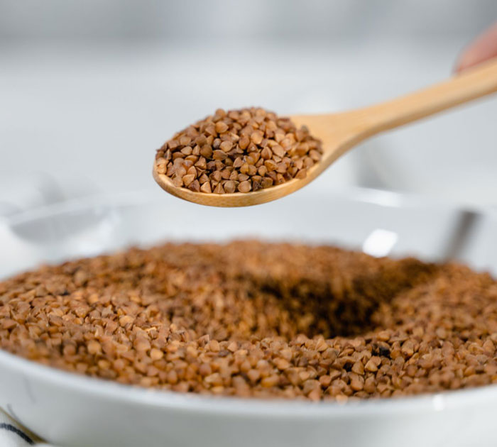 A spoon filled with buckwheat, representing gluten-free food options.