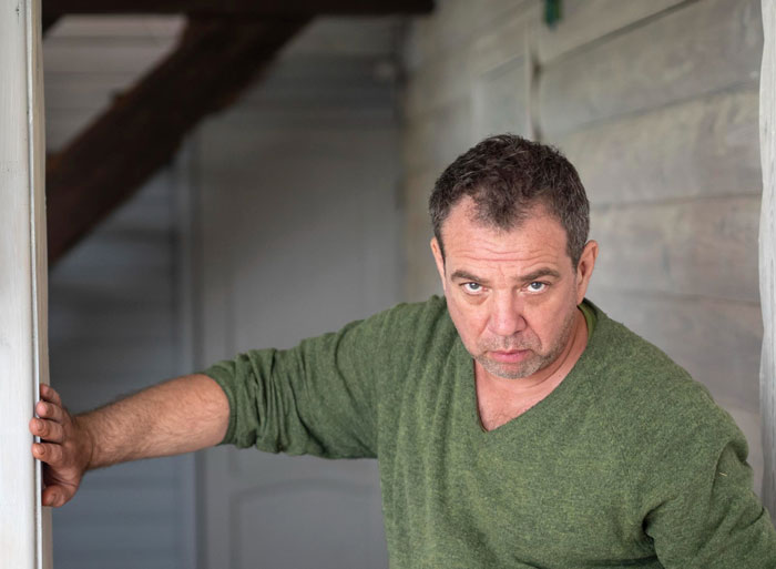 Angry middle-aged man in green sweater standing in doorway Angry middle-aged man in green sweater standing in doorway