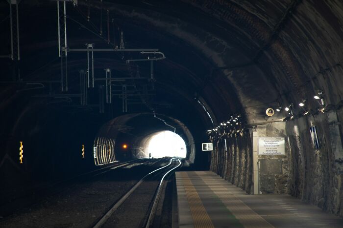 A dark train tunnel with a bright light at the end, representing the pursuit of answers to unsolved mysteries.