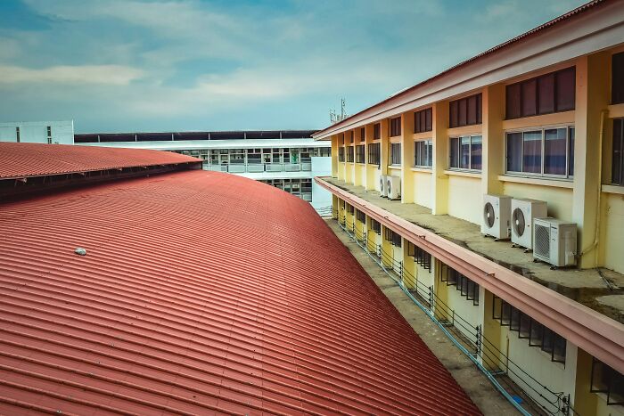 An overhead view of two buildings with red roofs, showing people who hid their true selves for years.