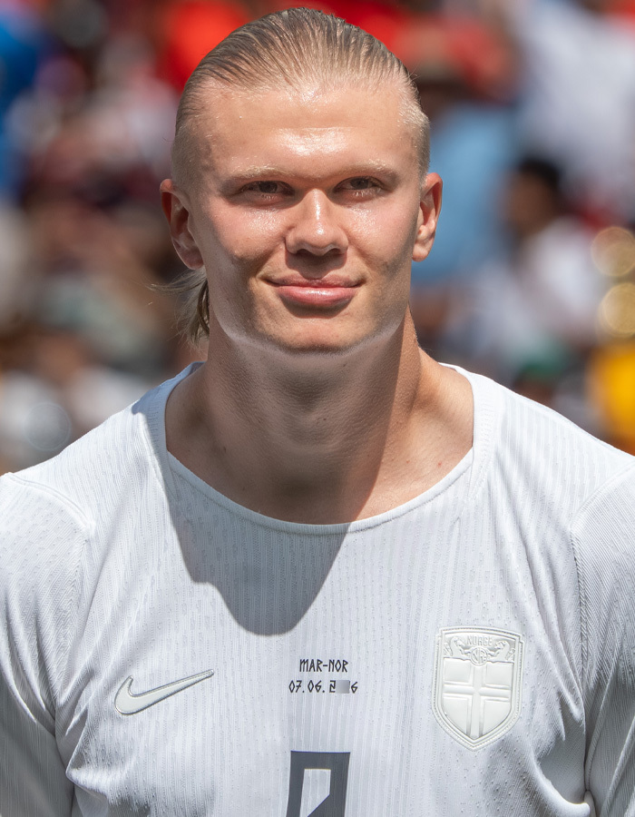 Norwegian soccer star with slicked back blonde hair in a white jersey, showcasing his iconic hair care. Norwegian soccer star with slicked back blonde hair in a white jersey, showcasing his iconic hair care.