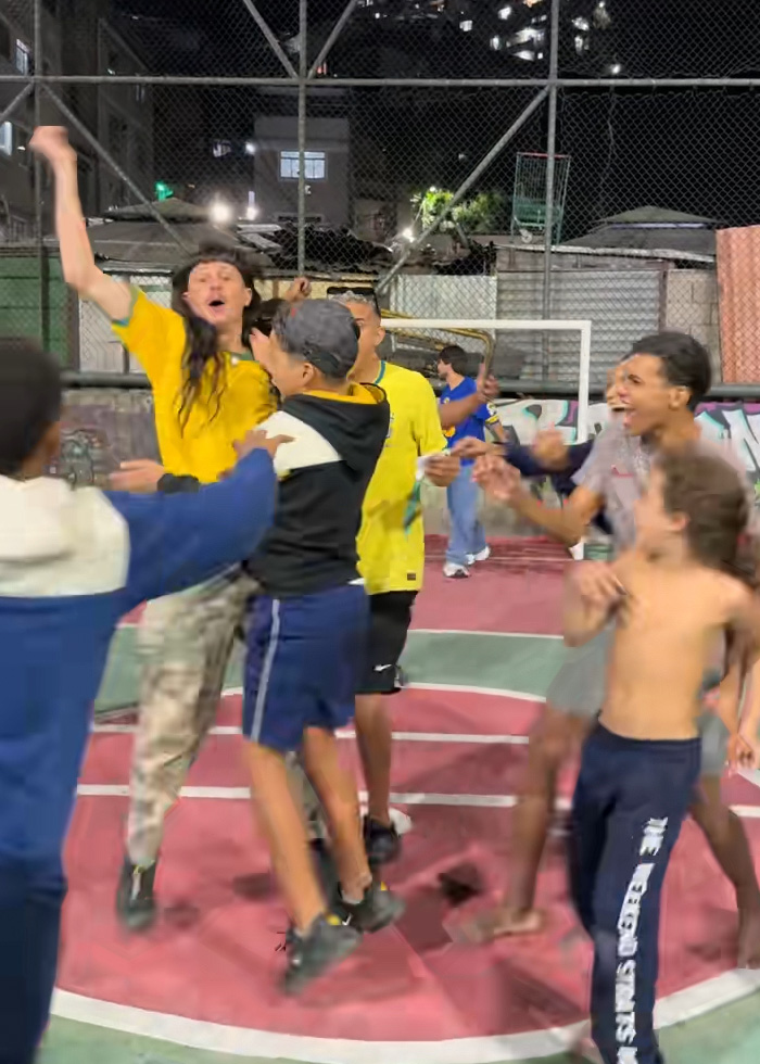 Oliver Tree celebrating with kids on a basketball court in Brazil wearing a yellow jersey Oliver Tree celebrating with kids on a basketball court in Brazil wearing a yellow jersey
