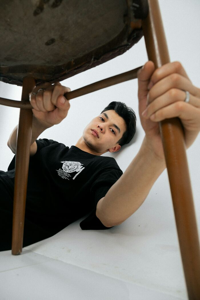 Teen holding chair upside down symbolizing class clown consequences