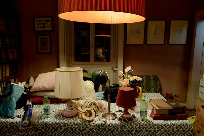 A cluttered room with various lamps and items on a table, symbolizing diverse environments for strange jobs.